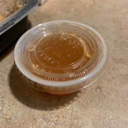 a plastic container with a sauce in it