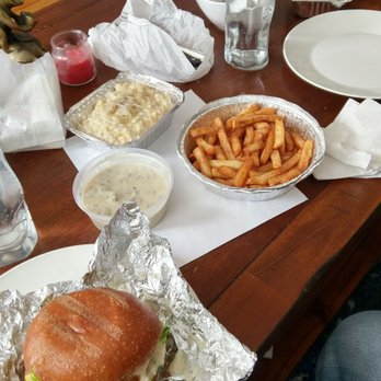 Take out order, burger, nosh fries with sausage gravy on the side in the circular container, mac and cheese in the rectangular container.