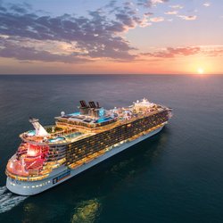 Cruise Planners - Jeffrey Lazo - Royal Caribbean ship sails into the sunset.