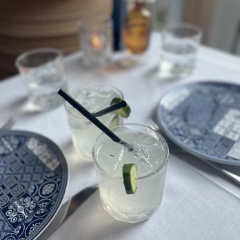 Hydra Estiatorio - two glasses of water and a plate with a slice of cucumber - Mediterranean Near Me - Vancouver, British Columbia