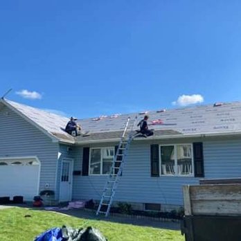 BMW Construction - a man on a ladder working on the roof of a house - General Contractors Near Me