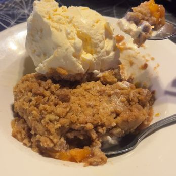 Red Rock Steakhouse & Bar - Peach cobbler and a large scoop of ice cream - Bars Near Me - Red Rock, Texas