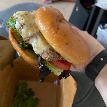 Curbside Creations - a hand holding a cheeseburger - Food Trucks Near Me Curbside Creations - a hand holding a cheeseburger - Food Trucks Near Me