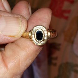 Absolute Diamond And Gold Buyers - 10K gold, oval shaped dark blue sapphire ring with diamonds surrounding it.