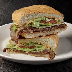 Fuego Cravings - A crispy breaded steak, beans, panela cheese, tomato, lettuce, onion, avocado, and our homemade FC chipotle spread.