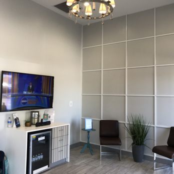 Ideal Dental Wilson - Waiting room with complimentary bottled water and television - Cosmetic Dentists Near Me - Wilson, North Carolina Ideal Dental Wilson - Waiting room with complimentary bottled water and television - Cosmetic Dentists Near Me - Wilson, North Carolina