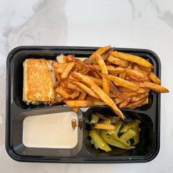 Abu Shawarma - Compact tray filled with more than a meal's worth of beef shawarma, fries, tahini sauce, pickle slices