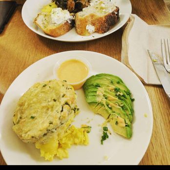 Cafe Madeline - Chive and cheddar biscuit with a side of avocado. Across the table the french plate with some pretty awesome goat cheese! - Breakfast & Brunch Near Me - Brooklyn, New York Cafe Madeline - Chive and cheddar biscuit with a side of avocado. Across the table the french plate with some pretty awesome goat cheese! - Breakfast & Brunch Near Me - Brooklyn, New York