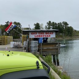 a green jeep parked next to a dock