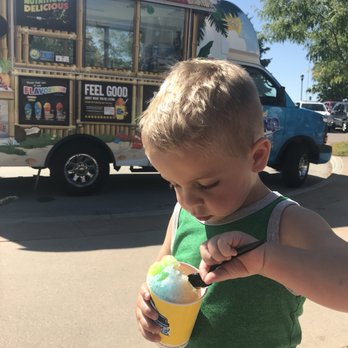 Kona Ice - a young boy eating an ice cream cone - Shaved Ice Near Me