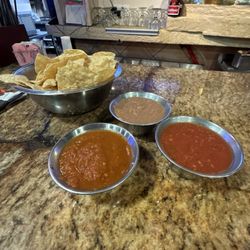 Chips and salsas. One beams, one warm and one rojo.