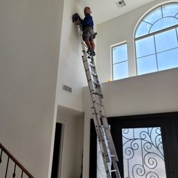 Dan in action 22 feet up, taking care to protect the walls Dan in action 22 feet up, taking care to protect the walls
