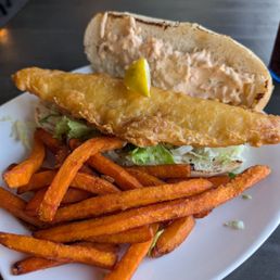 Fish sandwich and sweet potato fries. Fish sandwich and sweet potato fries.