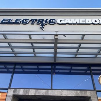 Immersive Gamebox - The photo captures the front of a commercial building with a sign displaying 'ELECTRIC GAMEBOX' in bold, stylized letters. The building features large glass windows and a modern architectural design, with a clear blue sky overhead. - Party & Event Planning Near Me - Murray, Utah