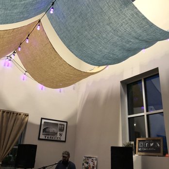 Eleven Lakes Brewing Company - a man playing a guitar in a room with a string of lights hanging from the ceiling - Breweries Near Me - Cornelius, North Carolina Eleven Lakes Brewing Company - a man playing a guitar in a room with a string of lights hanging from the ceiling - Breweries Near Me - Cornelius, North Carolina
