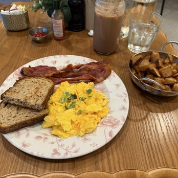 Café Bastille Downtown Miami - Scrambled eggs, bacon, and breakfast potatoes, with a side of toast. Iced mocha latte. - French Near Me - Miami, Florida