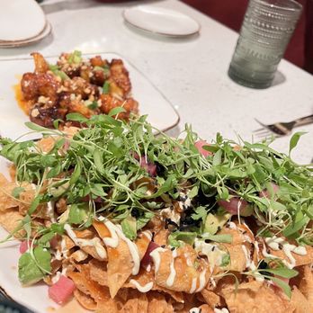 SeventyOne - Ahi tuna nacho, Korean fried cauliflower - Fried wontons topped with microgreens, drizzled with white and black sauces, served on a white plate at a restaurant. - American Near Me - Snowbird, Utah