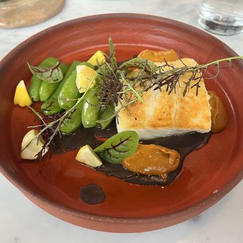 Lilia Comedor - Alaskan halibut with a black bean jus and squash blossom mole and snap peas. This was so good. We were wiping up all the bean sauce and mole - French Near Me - Portland, Oregon