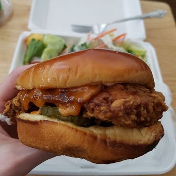 Huey P's Pizzeria & Daiquiris - a hand holding a chicken sandwich - Pizza Near Me - Violet, Louisiana Huey P's Pizzeria & Daiquiris - a hand holding a chicken sandwich - Pizza Near Me - Violet, Louisiana