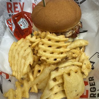 REV Burger - Gluten free rev burger and waffle fries - A burger with a bun, cheese, and bacon is accompanied by waffle fries on branded REV Burger paper. - Burgers Near Me - Beverly, Massachusetts