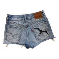 Hand painted IWA bird print on women's Levis custom cut off denim shorts.