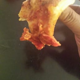 a hand holding a piece of pizza a hand holding a piece of pizza