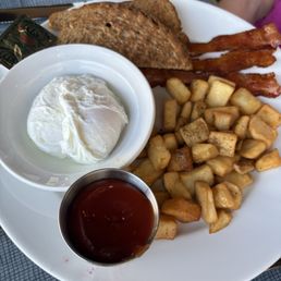 Two poached eggs, bacon and potatoes. Two poached eggs, bacon and potatoes.