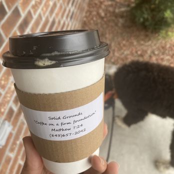 Solid Grounds Coffee Shop - a hand holding a coffee cup - Coffee & Tea Near Me - Turbeville, South Carolina Solid Grounds Coffee Shop - a hand holding a coffee cup - Coffee & Tea Near Me - Turbeville, South Carolina