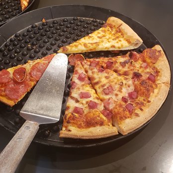 Pizza Ranch - a pizza on a pizza pan with a pizza cutter - Pizza Near Me - Grand Island, Nebraska