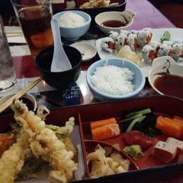 Lunch tempura box with sushi and rice. Spicy tuna roll in the background Lunch tempura box with sushi and rice. Spicy tuna roll in the background