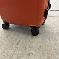 Advance Check-In - Damage from Advanced Check-In, July 2026. The crack pushed into the wheel housing, making the suitcase difficult to roll through the airport