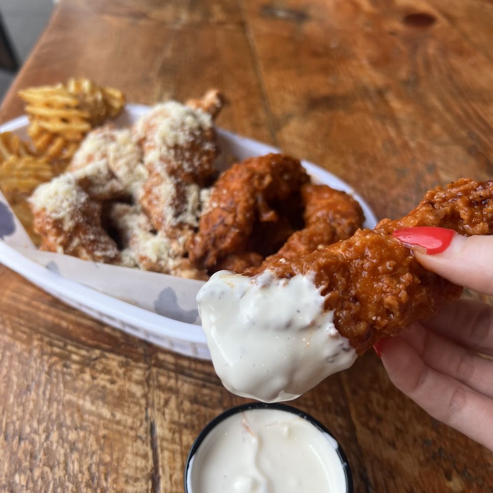 Wing Bar - hand holding a piece of fried chicken - Chicken Wings Near Me - Jersey City, New Jersey Wing Bar - hand holding a piece of fried chicken - Chicken Wings Near Me - Jersey City, New Jersey
