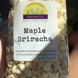 a hand holding a bag of popcorn