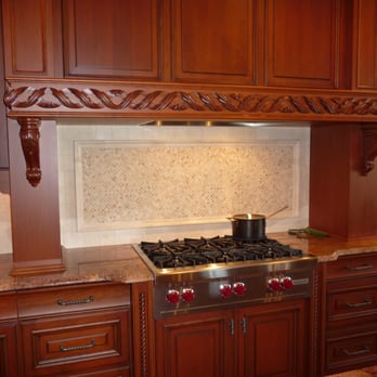 Holcomb Cabinetry - a kitchen with wood cabinets and a stove - General Contractors Near Me - Claymont, Delaware