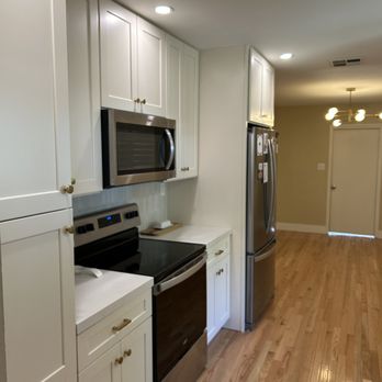 Thiel Construction - a kitchen with white cabinets and stainless steel appliances - General Contractors Near Me - Modesto, California