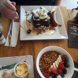 The Breakfast Club - Our breakfast. At the top, banana bread french toast. At the bottom, granola bowl with fruit and yogurt, and a croissant.