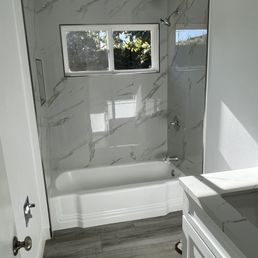 a bathroom with a tub, sink, and window