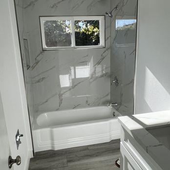 Beach City Flooring & Beyond - a bathroom with a tub, sink, and window - Flooring Near Me - San Clemente, California