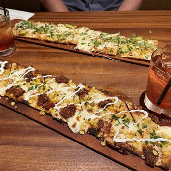 Seasons 52 - Corn and bacon flatbread (front) Lobster and avocado flatbread (back) New old fashioned drinks - New American Near Me - Schaumburg, Illinois