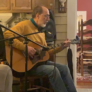 Peacock House - Co-owner Jim picking out a tune on the house guitar - Hotels Near Me - Lubec, Maine