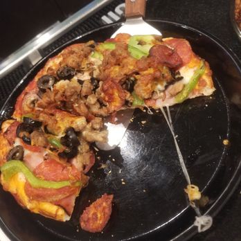 Straw Hat Pizza - a half eaten pizza on a black plate - Pizza Near Me - San Jose, California Straw Hat Pizza - a half eaten pizza on a black plate - Pizza Near Me - San Jose, California
