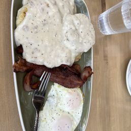 Eggs, bacon and gravy over biscuits