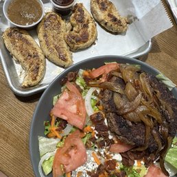 Burger patty on a salad and grilled chicken tenders