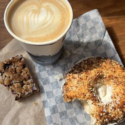 Latte with almond milk, everything bagel with vegan cream cheese, and a vegan blackberry bar of some kind