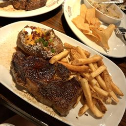 Outlaw Ribeye with sides of Loaded Baked Potato and Seasoned French Fries Outlaw Ribeye with sides of Loaded Baked Potato and Seasoned French Fries