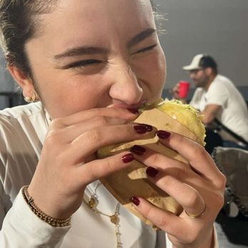 Las Arepas De Maria - A girl eating an arepa. - Venezuelan Near Me - Miami, Florida