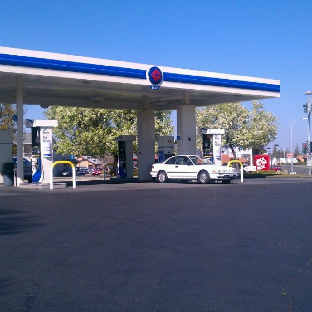 a gas station with cars parked in front of it a gas station with cars parked in front of it