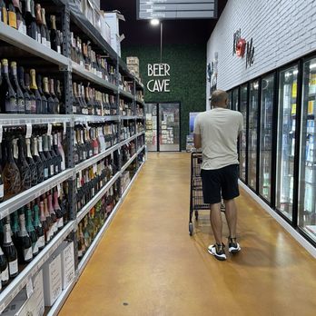 Strong Water - a man pushing a shopping cart through a store aisle - Beer, Wine & Spirits Near Me - Lilburn, Georgia