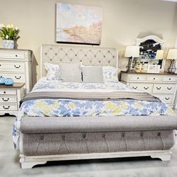 Ashley Store + Outlet - sleigh bed with a Purple mattress.