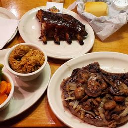 20 oz. Bone-In Ribeye with sautéed mushrooms and onions done medium-rare, fresh vegetables, rice, ribs.